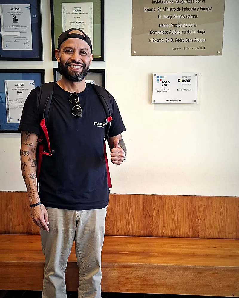 Manuel con la camiseta de Studio 42 en la sede de la ADER en Logroño, sonriendo con el pulgar arriba