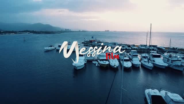 Marina con lanchas y montañas al fondo, vista aérea